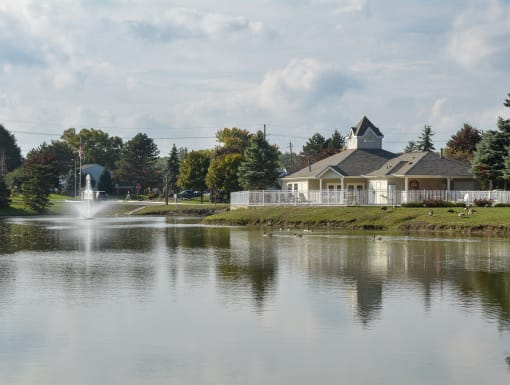 a view of a lake with a fountain and a house