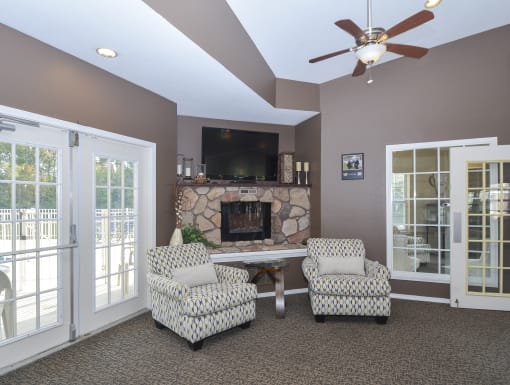 a living room with a fireplace and two chairs