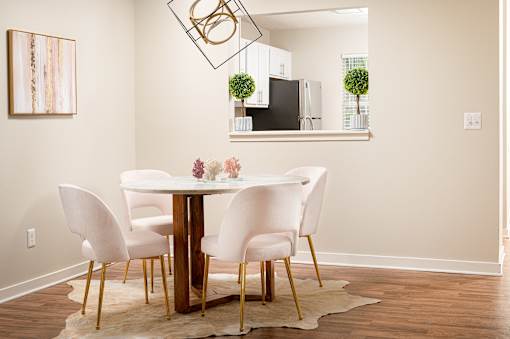 Dining room with white table and chairs at Southwind Apartments in Richland, MS.