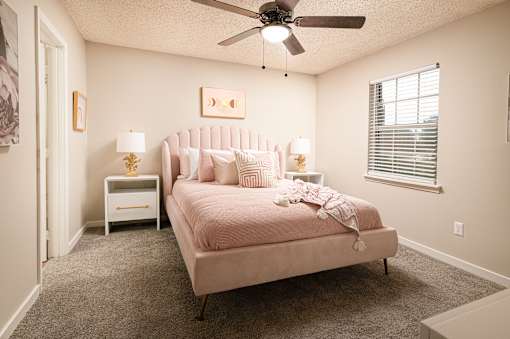 Bedroom featuring a pink bed and ceiling fan at Southwind Apartments in Richland, MS.