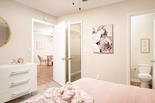 Cozy bedroom with bed, dresser, and wall art at Southwind Apartments in Richland, MS.