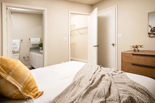 Bedroom with bed, dresser, and mirror at Southwind Apartments in Richland, MS.