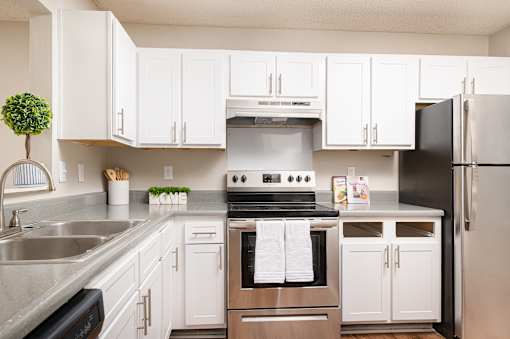 Modern kitchen with white cabinets and stainless steel appliances at Southwind Apartments in Richland, MS.