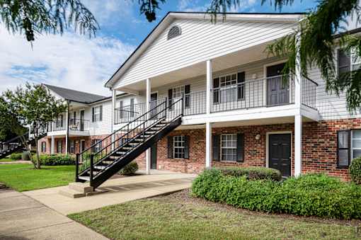 Apartment building exterior with white siding and black door and windows at Southwind Apartments in Richland, MS.