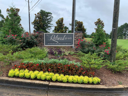 a sign for the relentless landscaping company in front of a garden