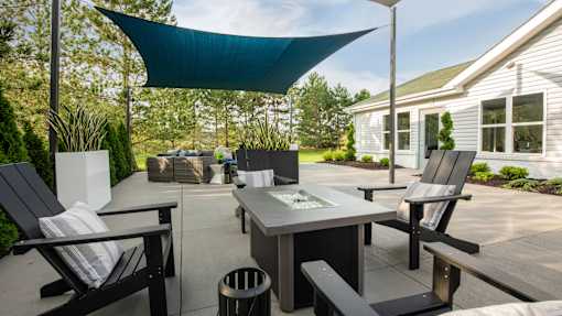 A patio with a table, chairs and a canopy.