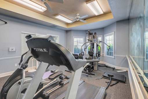 Treadmill in apartment fitness center with ceiling fan at Cambury Hills Apartments in Omaha, Nebraska