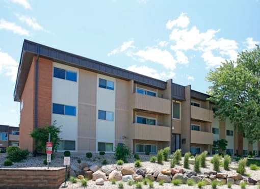 A modern apartment building with a red, white, and beige color scheme.