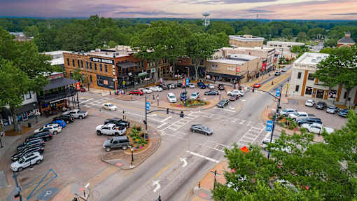 A city intersection with cars and buildings.