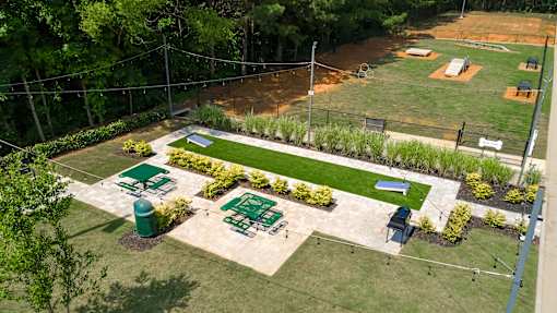 A park with a green lawn and a baseball field.