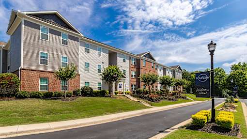 A street view of a residential area with apartment buildings and a street lamp.