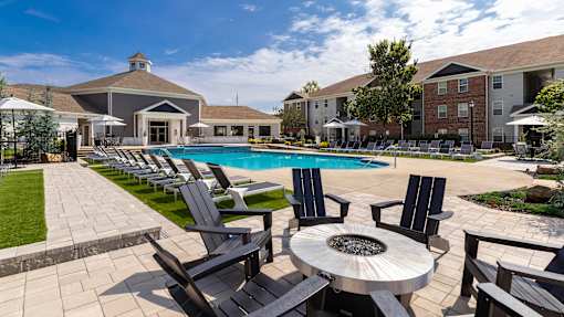 A poolside area with chairs and a table.