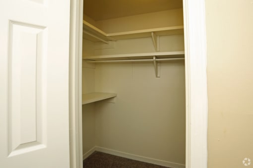 a walk in closet with shelves and a window