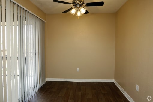 a living room with a ceiling fan and a window