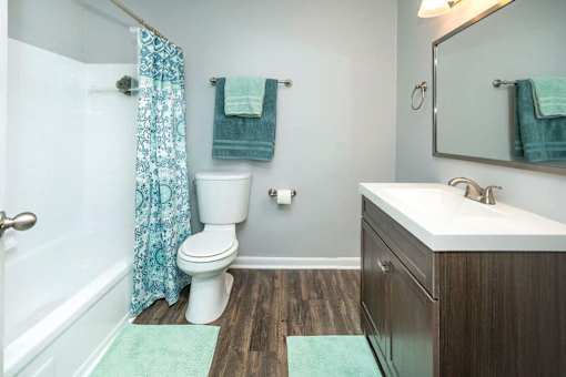 A white toilet sits next to a white sink in a bathroom.