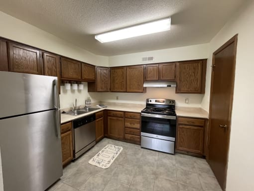 a kitchen with stainless steel appliances and wooden cabinets