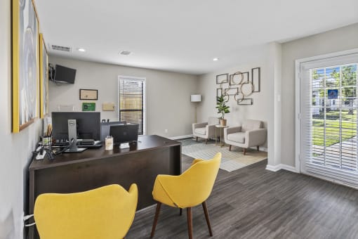 an office with yellow chairs and a desk and a window