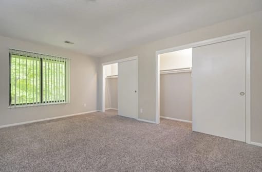 an empty living room with white walls and a window