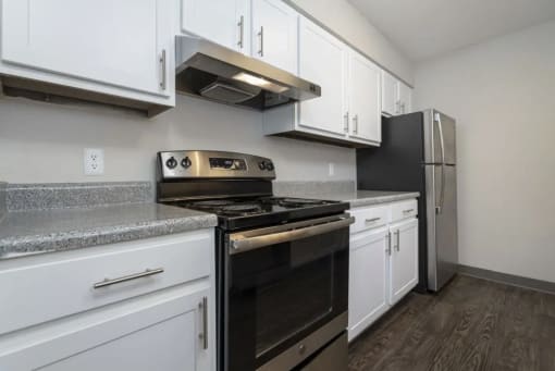 a kitchen with white cabinets and a stove and a refrigerator