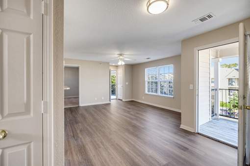 A spacious room with wooden floors and white walls.