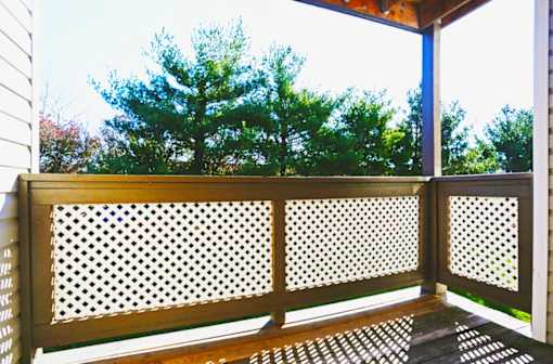 A wooden deck with a lattice design on the railing.