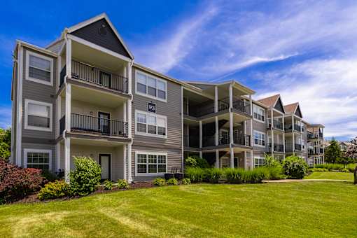 A large apartment complex with multiple balconies and green lawns.