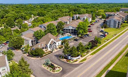 A bird's eye view of a residential area with houses and a swimming pool.