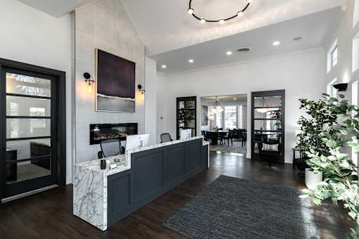 A reception area with a white reception desk and a grey rug.