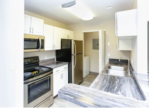 a kitchen with stainless steel appliances and white cabinets