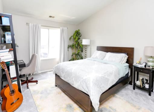 a bedroom with a bed and a guitar in it