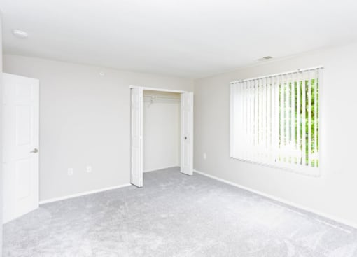 an empty room with a white wall and a window