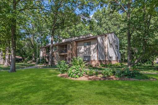 a house in the middle of a yard with trees