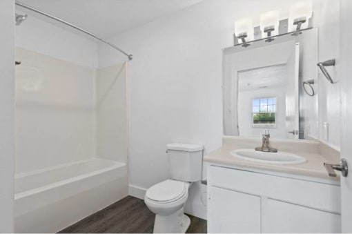 a white bathroom with a sink toilet and a shower