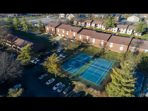 a tennis court in front of a row of houses