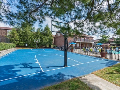 a blue basketball court in front of a brick building
