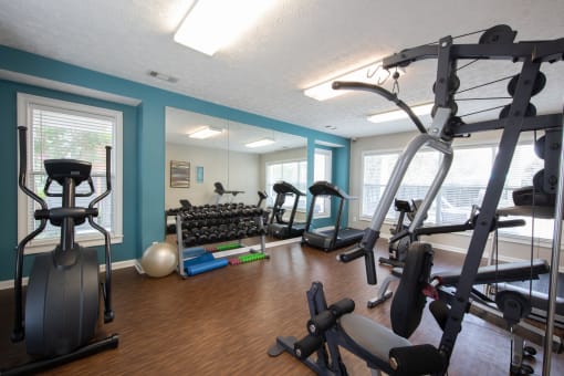 a gym with cardio equipment and weights