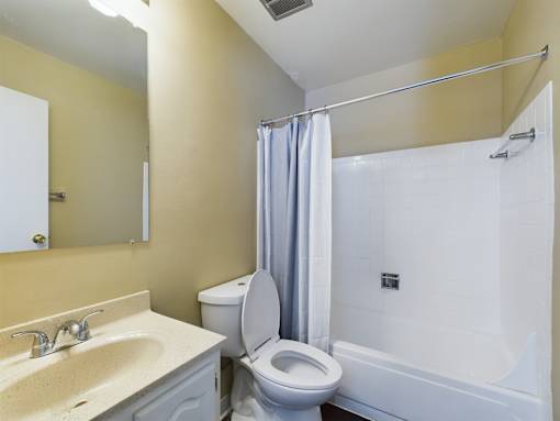 A bathroom with a toilet, sink, and bathtub.