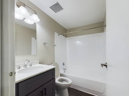 A bathroom with a white sink, toilet, and bathtub.
