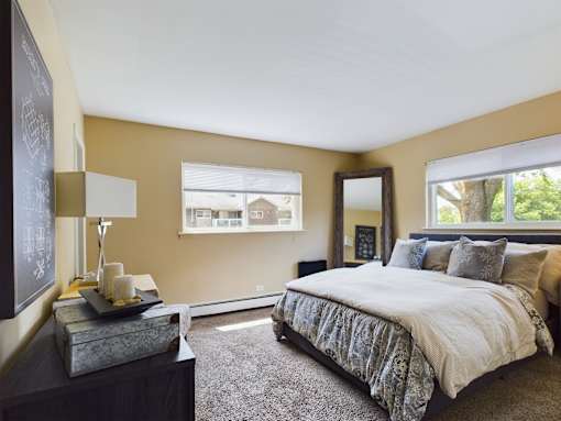 A bedroom with a large bed and a chalkboard on the wall.