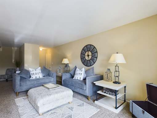 A living room with grey couches and a white coffee table.