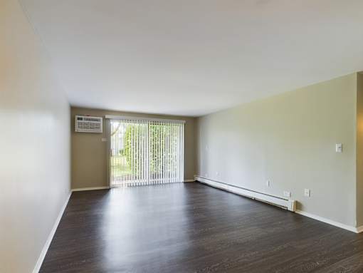 A room with a sliding glass door leading to a balcony.