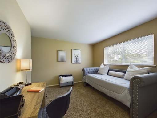 A bedroom with a bed, desk, and chair.