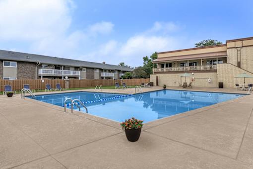 A large outdoor swimming pool with a concrete floor and a concrete edge.