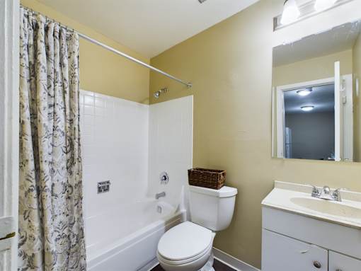 A bathroom with a toilet, sink, and shower.