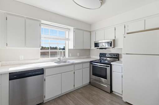 A kitchen with white cabinets and stainless steel appliances.