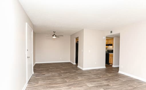 A room with a ceiling fan and wooden flooring.