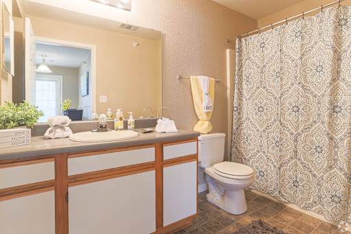 Clean, full bathroom with toilet, sink, and shower in an apartment home at Waterbrook Apartments in Lincoln, Nebraska, professionally operated by Highlands Vista Group.