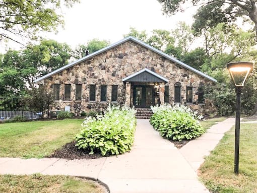 a small stone house with a sidewalk in front of it