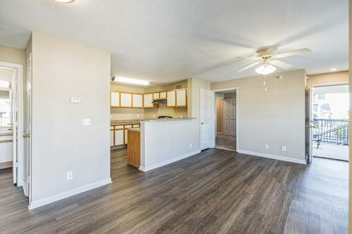 A spacious living room with a kitchen in the background.