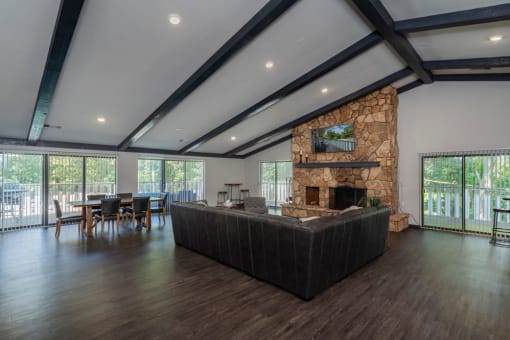 a large living room with a large stone fireplace and a table and chairs